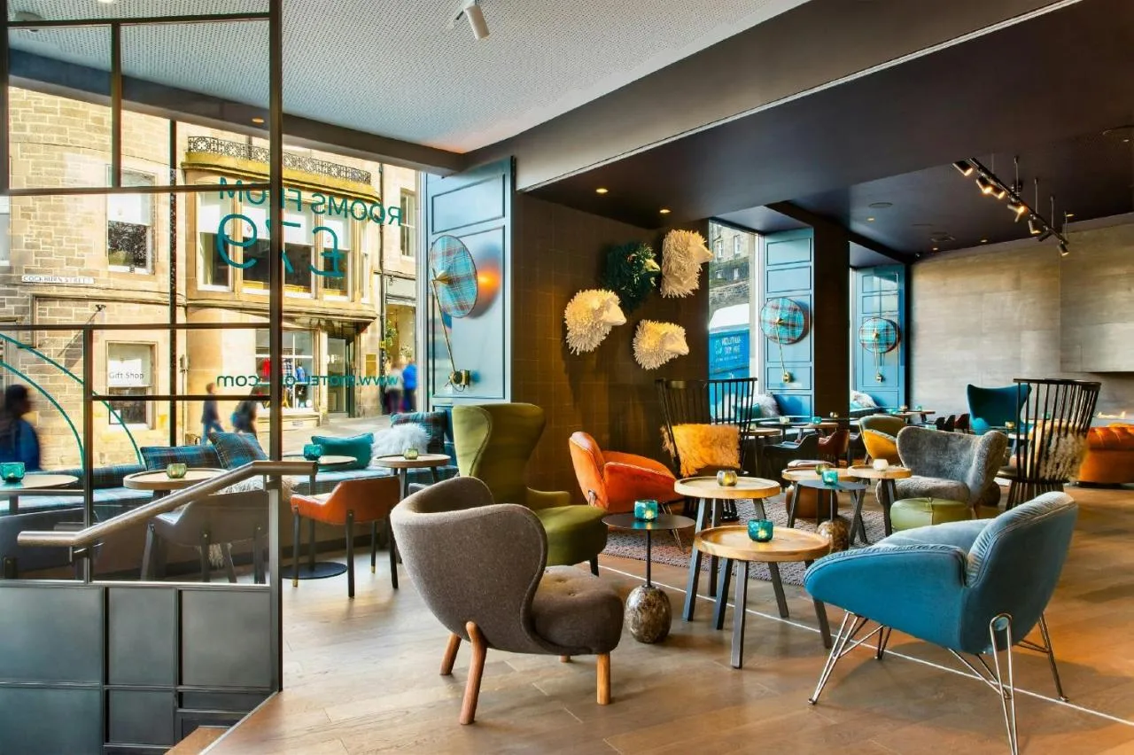 a restaurant with colorful chairs and tables in a room at Motel One Edinburgh-Royal in Edinburgh