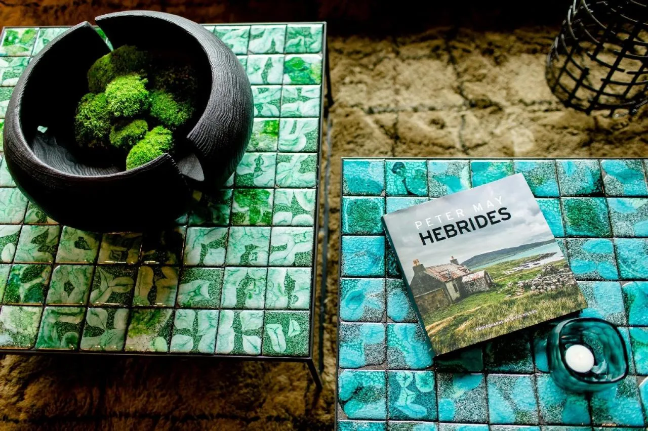 a pot of broccoli and a book on a table at Motel One Edinburgh-Royal in Edinburgh